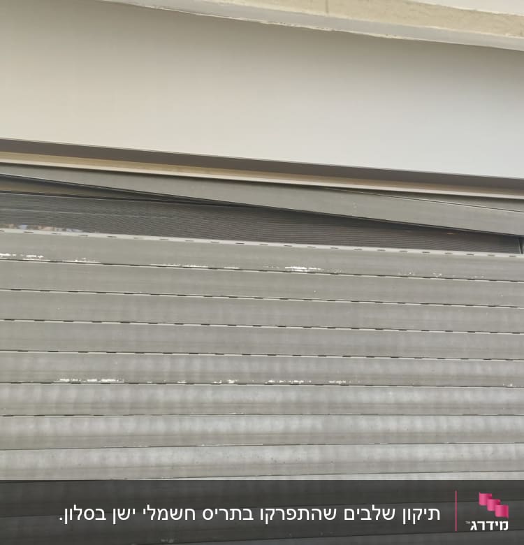 תריס מתכת אפור עם מצלמת אבטחה בצד שמאל